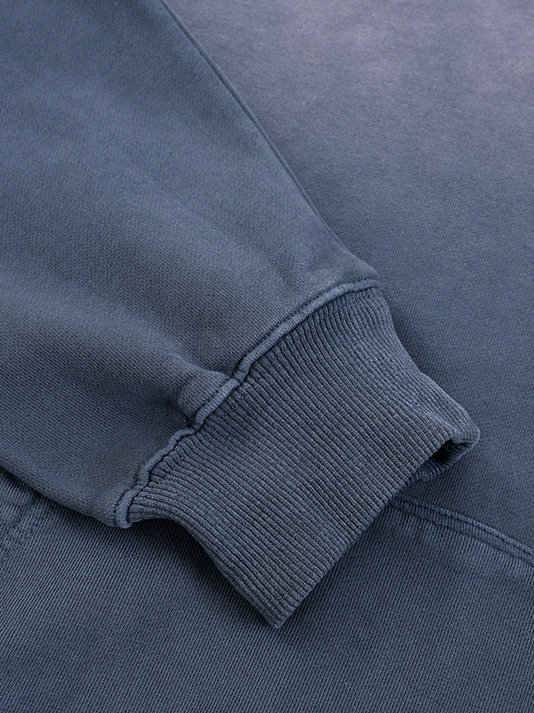 Load image into Gallery viewer, Close-up of a blue sweatshirt with ribbed cuffs and waistband.