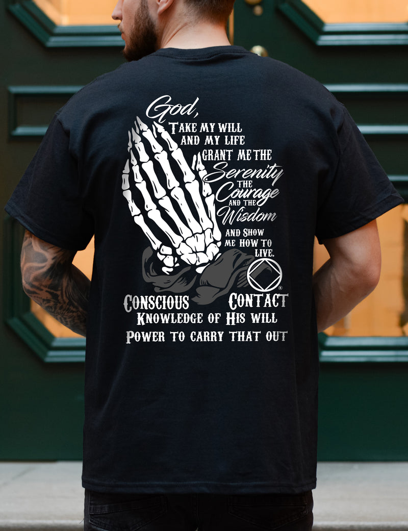 Load image into Gallery viewer, Person wearing a black t-shirt with white text and design on the back, standing in front of a green door.
