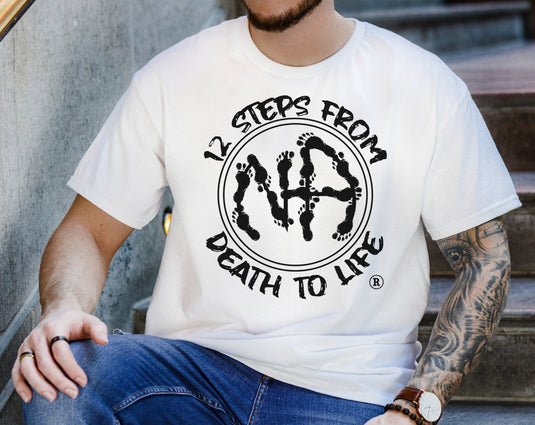 Person wearing a white t-shirt with a black graphic design and text.