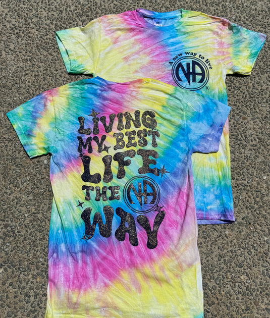 Tie-dye t-shirt with text 'LIVING MY BEST LIFE THE WAY' and a logo on the upper front, displaying a range of colors including blue, pink, yellow, and purple.