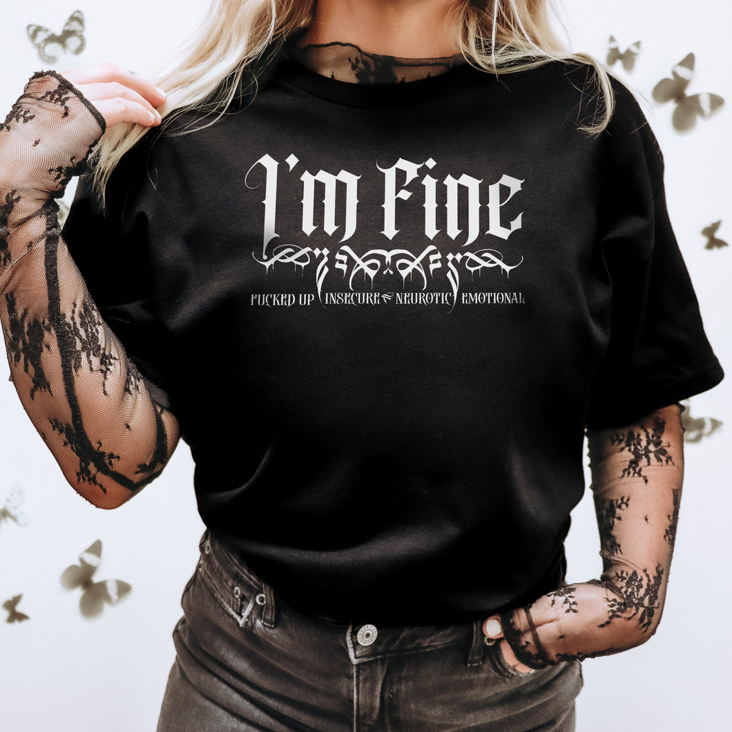 Black Gildan 64000L Ladies T-shirt with white text that reads ' I'm FINE- Fucked-up, Insecure,Neurotic, Emotional' on female model with long blonde hair wearing lace sleeves adn black jeans with black butterflys in the background