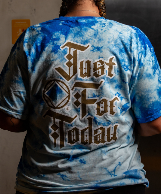 Person wearing a blue and white tie-dye t-shirt with text on the back.