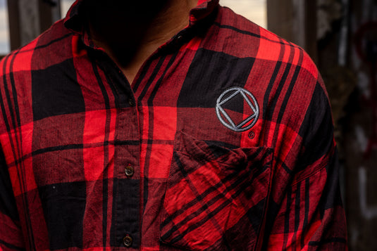 Red and black plaid shirt with a logo on the chest