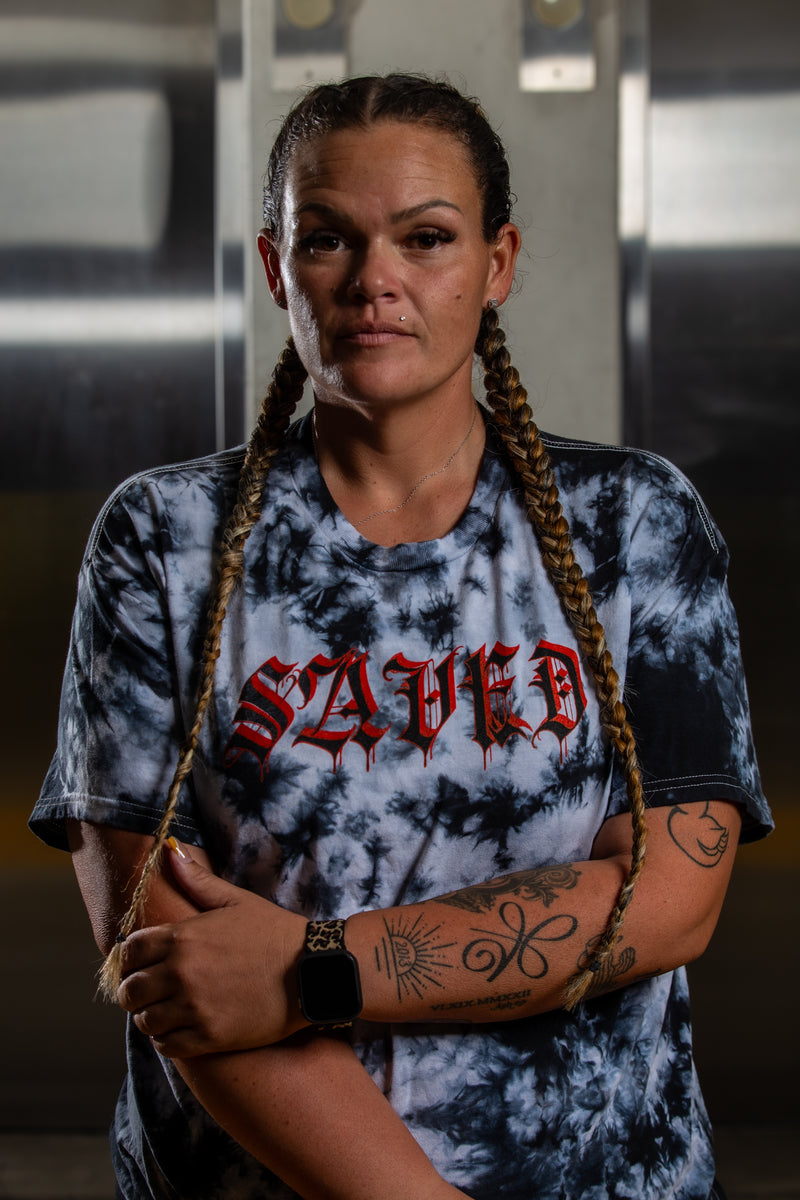 Load image into Gallery viewer, Person wearing a tie-dye shirt with 'SAVED' text, standing indoors.
