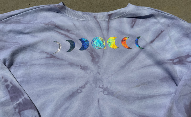 Load image into Gallery viewer, Tie-dye shirt with colorful moon phases design on a neutral background
