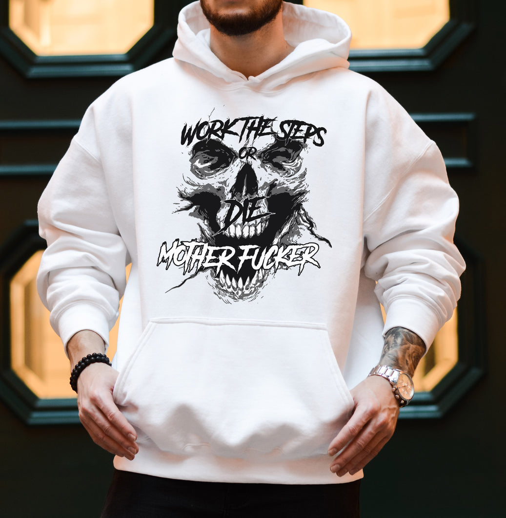 Man with a tattoo standing in front of a green and pale yellow wall wearing a white hooded hoodie/sweatshirt with a black screaming skeleton skull face with text on top that says 